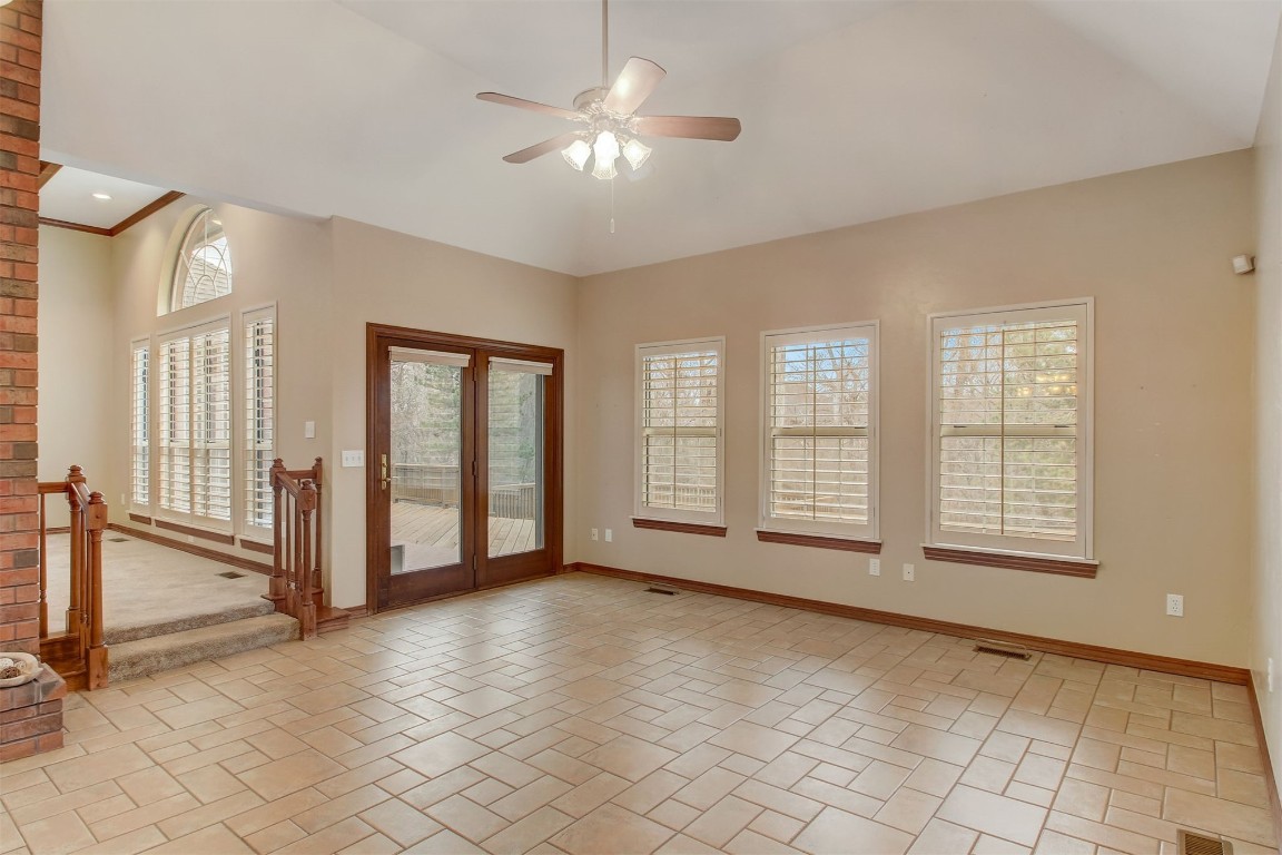695 Kingsgate Road, Yukon, OK 73099 tiled spare room featuring a wealth of natural light, ornamental molding, brick wall, and ceiling fan