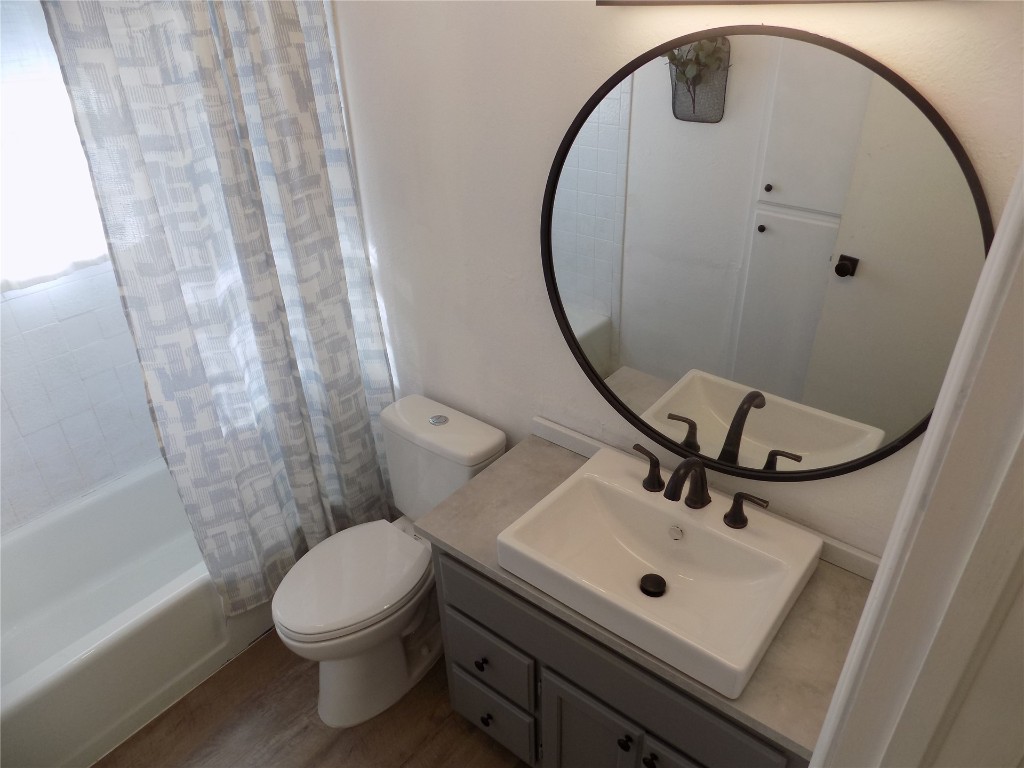 2706 CS 2831, Chickasha, OK 73018 full bathroom featuring toilet, large vanity, hardwood / wood-style floors, and shower / bath combination with curtain