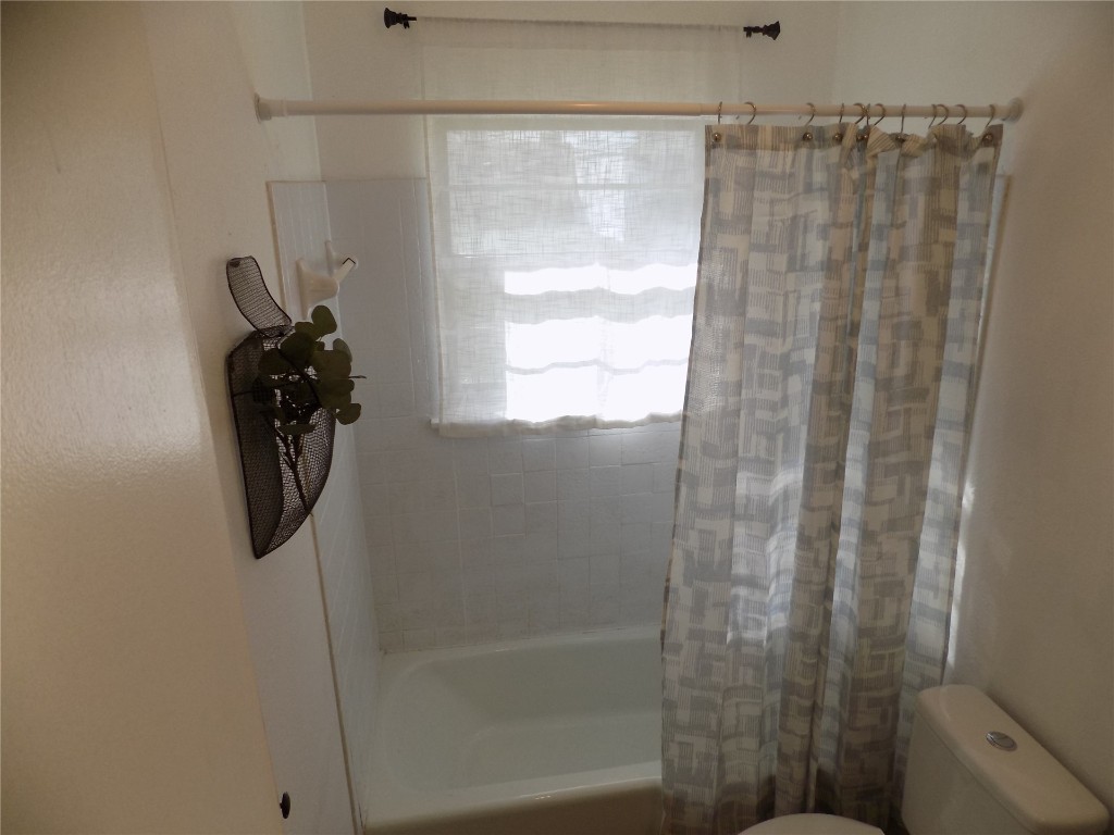 2706 CS 2831, Chickasha, OK 73018 bathroom with toilet and shower / bath combo with shower curtain