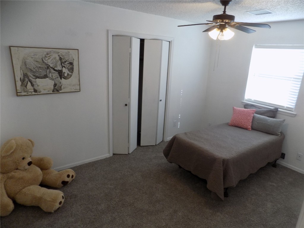 2706 CS 2831, Chickasha, OK 73018 bedroom featuring dark colored carpet, a textured ceiling, and ceiling fan