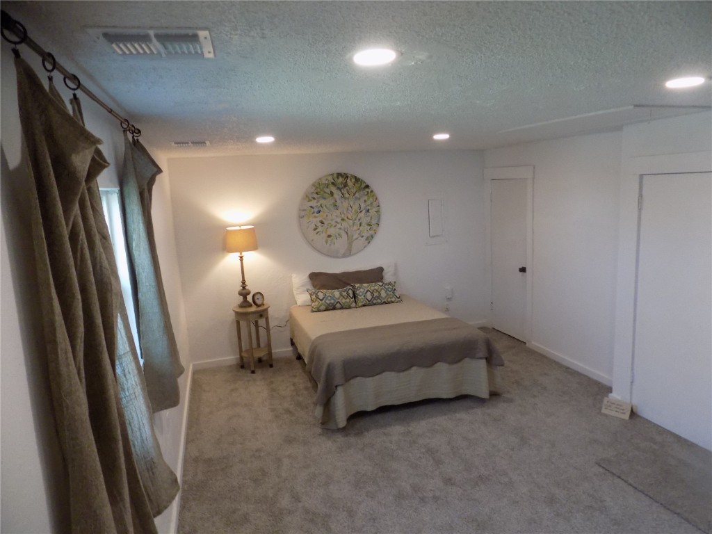 2706 CS 2831, Chickasha, OK 73018 bedroom with light carpet and a textured ceiling