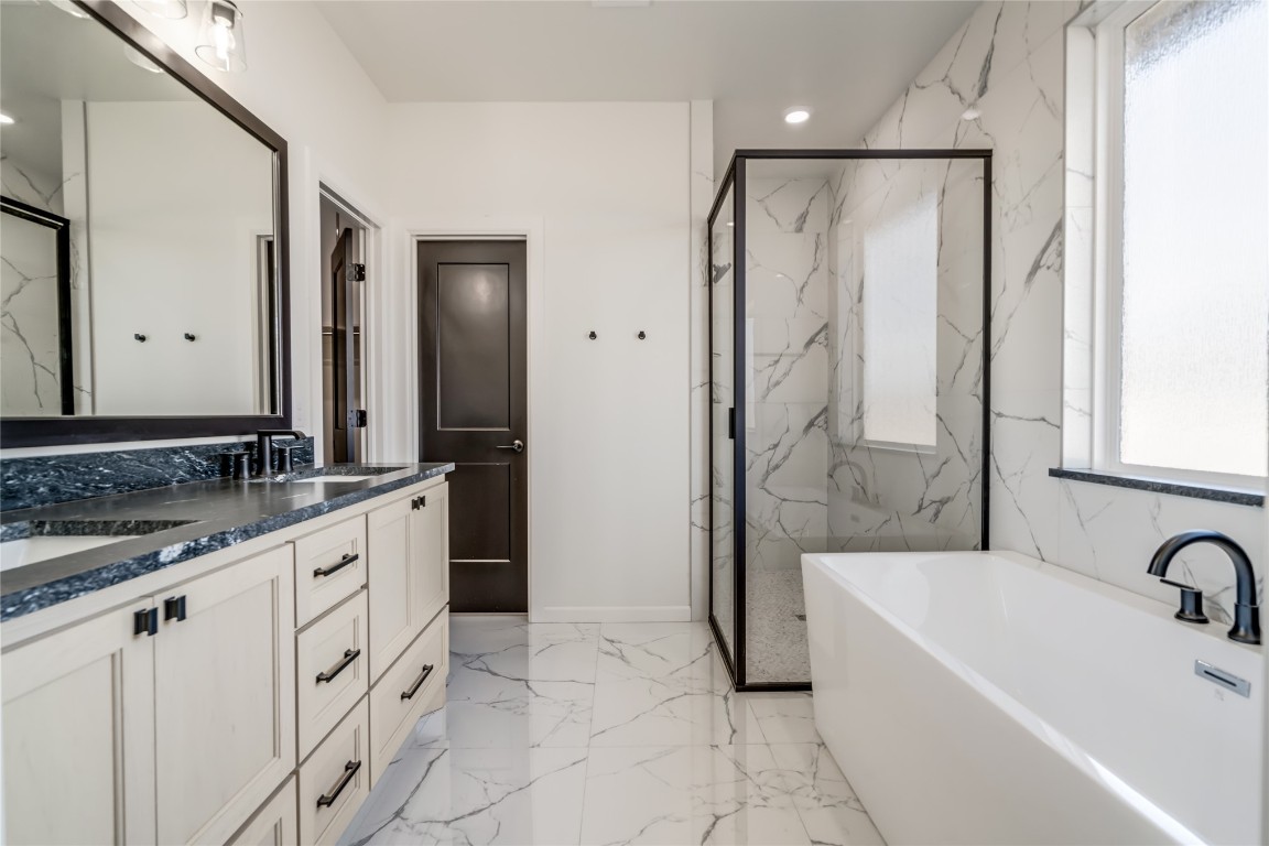 10716 Swift Circle, Yukon, OK 73099 bathroom featuring dual bowl vanity, shower with separate bathtub, and tile flooring
