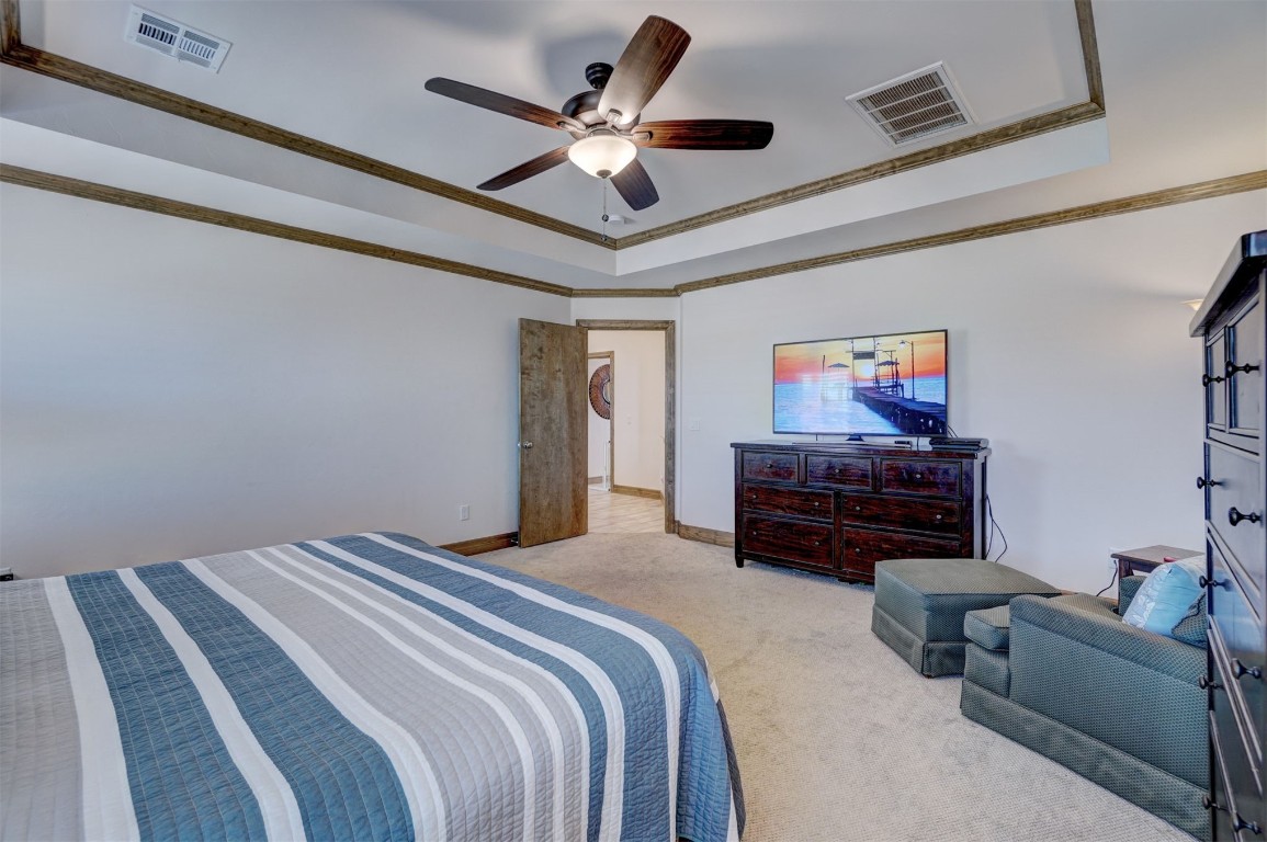 5851 Starry Night, Piedmont, OK 73078 carpeted bedroom featuring a raised ceiling, crown molding, and ceiling fan