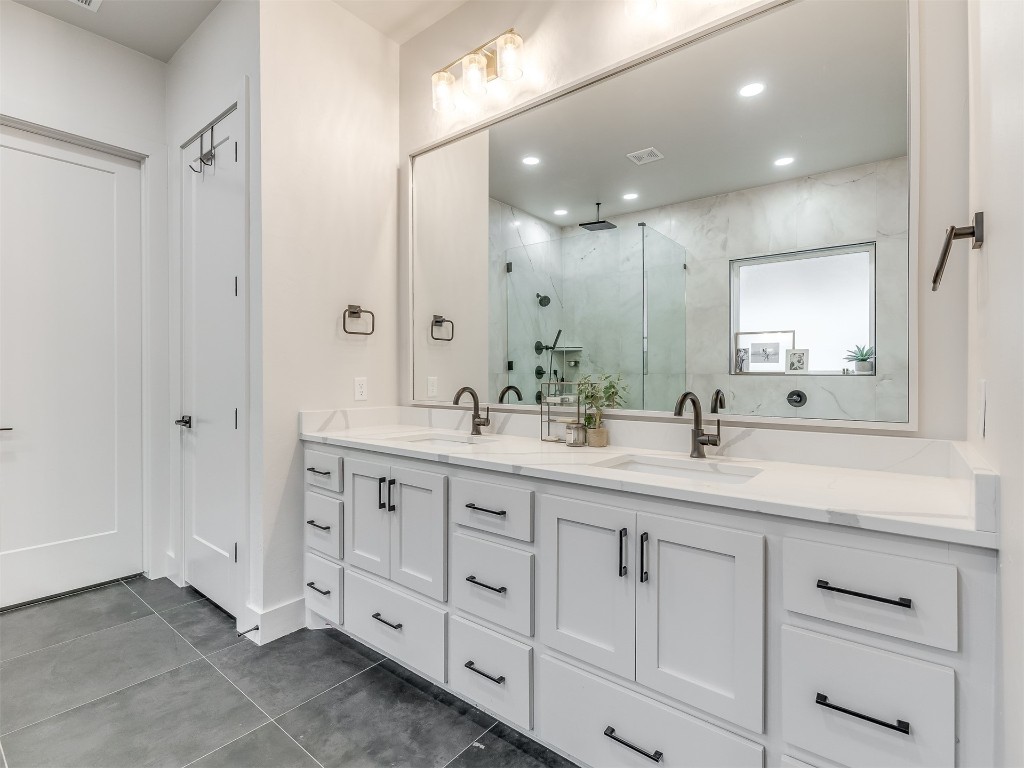 14504 Chambord Drive, Yukon, OK 73099 bathroom with walk in shower, tile floors, and double sink vanity