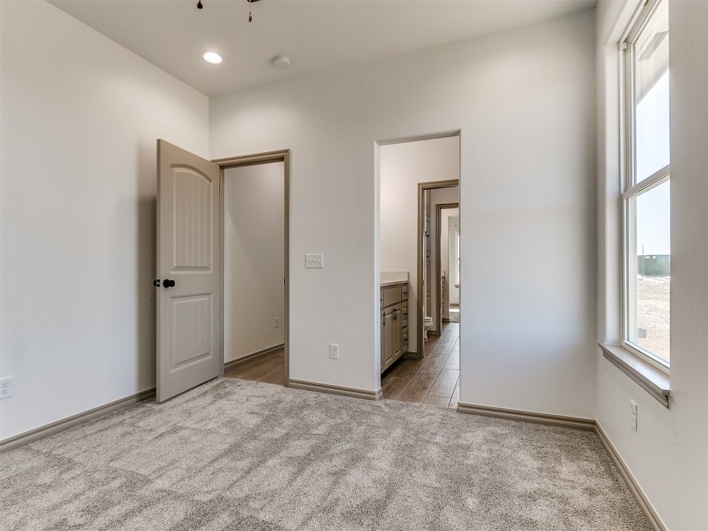 16755 Pondview Lane, Yukon, OK 73099 unfurnished bedroom featuring light carpet