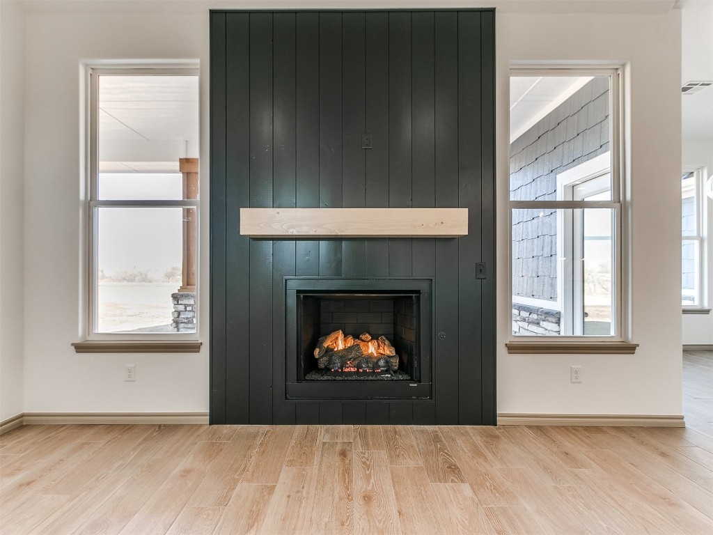 16755 Pondview Lane, Yukon, OK 73099 interior details with a large fireplace and light hardwood / wood-style flooring