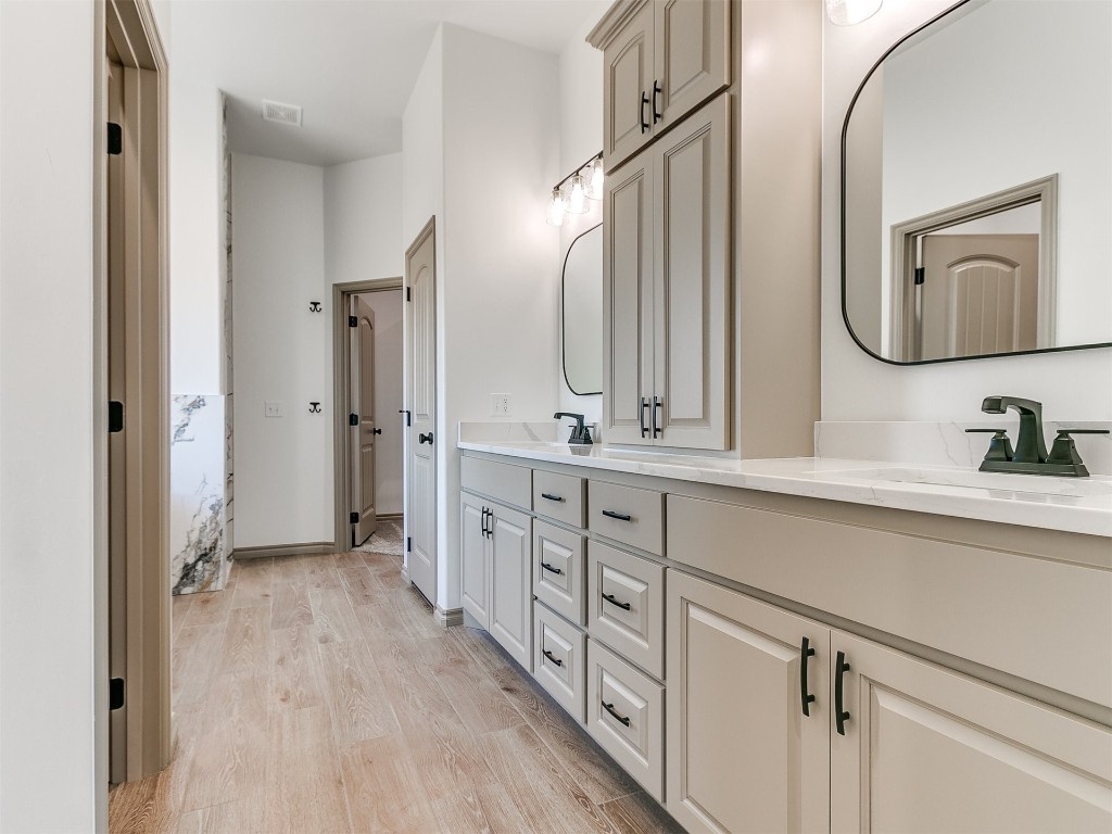 16755 Pondview Lane, Yukon, OK 73099 bathroom featuring hardwood / wood-style flooring, large vanity, and dual sinks