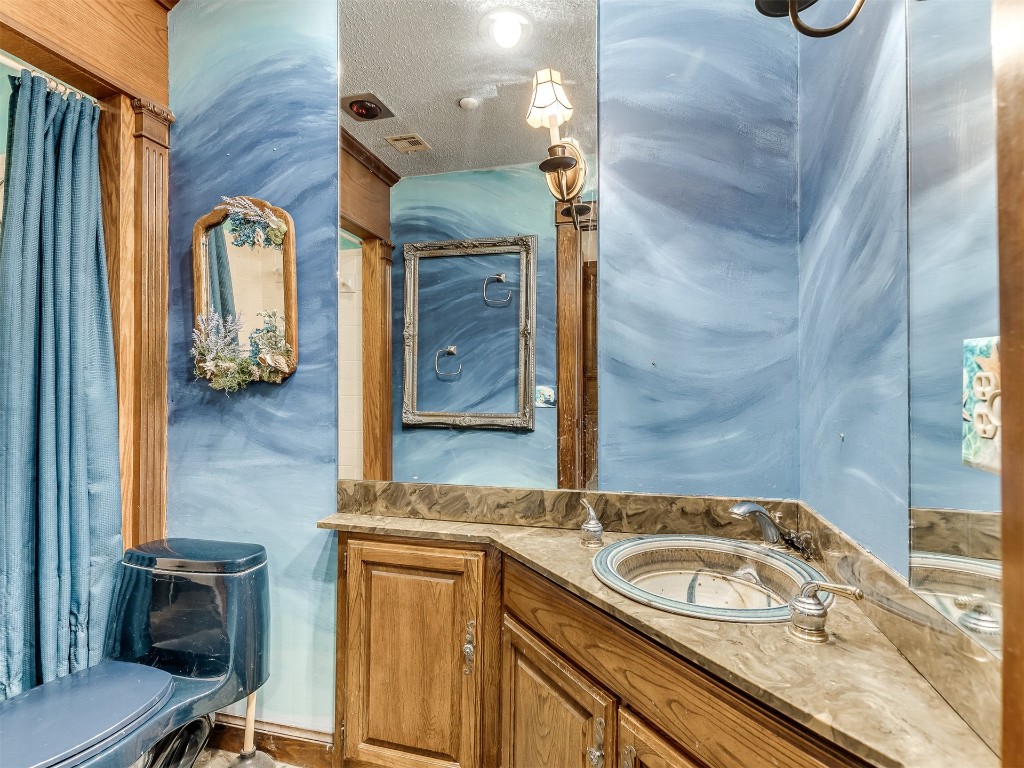 7149 NW 16th Street, Bethany, OK 73008 bathroom with a textured ceiling, large vanity, and toilet