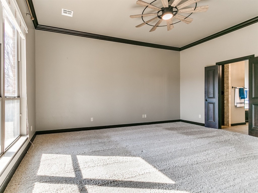 4708 NW 153rd Street, Edmond, OK 73013 carpeted empty room featuring ornamental molding and ceiling fan