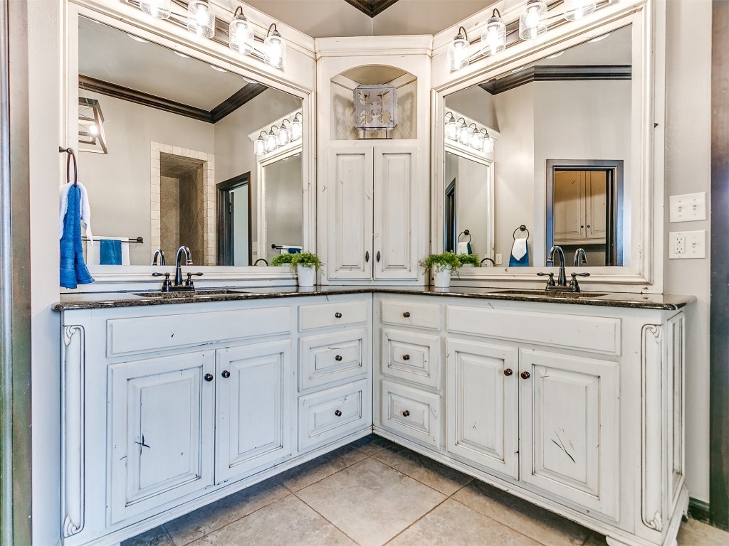 4708 NW 153rd Street, Edmond, OK 73013 bathroom featuring a bath, ornamental molding, a notable chandelier, tile flooring, and dual vanity