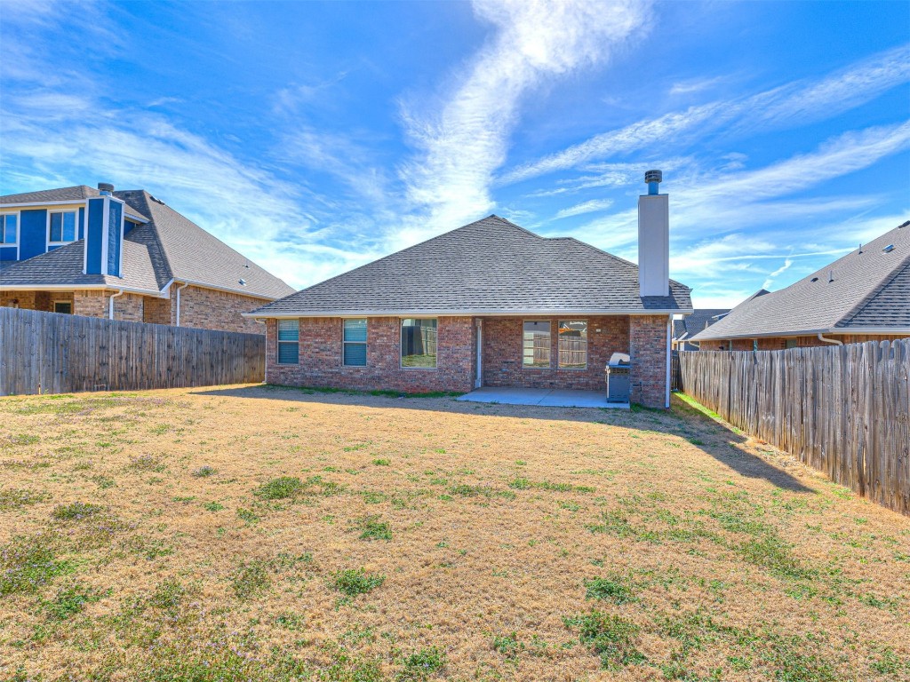 3337 NW 187th Street, Edmond, OK 73012 back of house with a lawn and a patio
