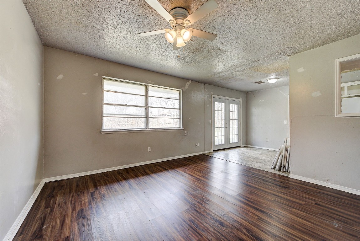 8709 N Hudson Avenue, Oklahoma City, OK 73114 spare room featuring french doors, dark hardwood / wood-style floors, a textured ceiling, and ceiling fan