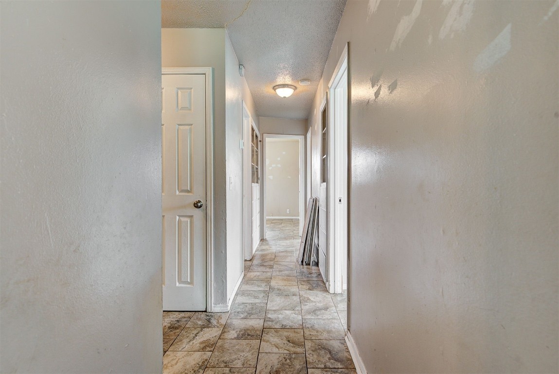 8709 N Hudson Avenue, Oklahoma City, OK 73114 hallway with light tile floors and a textured ceiling