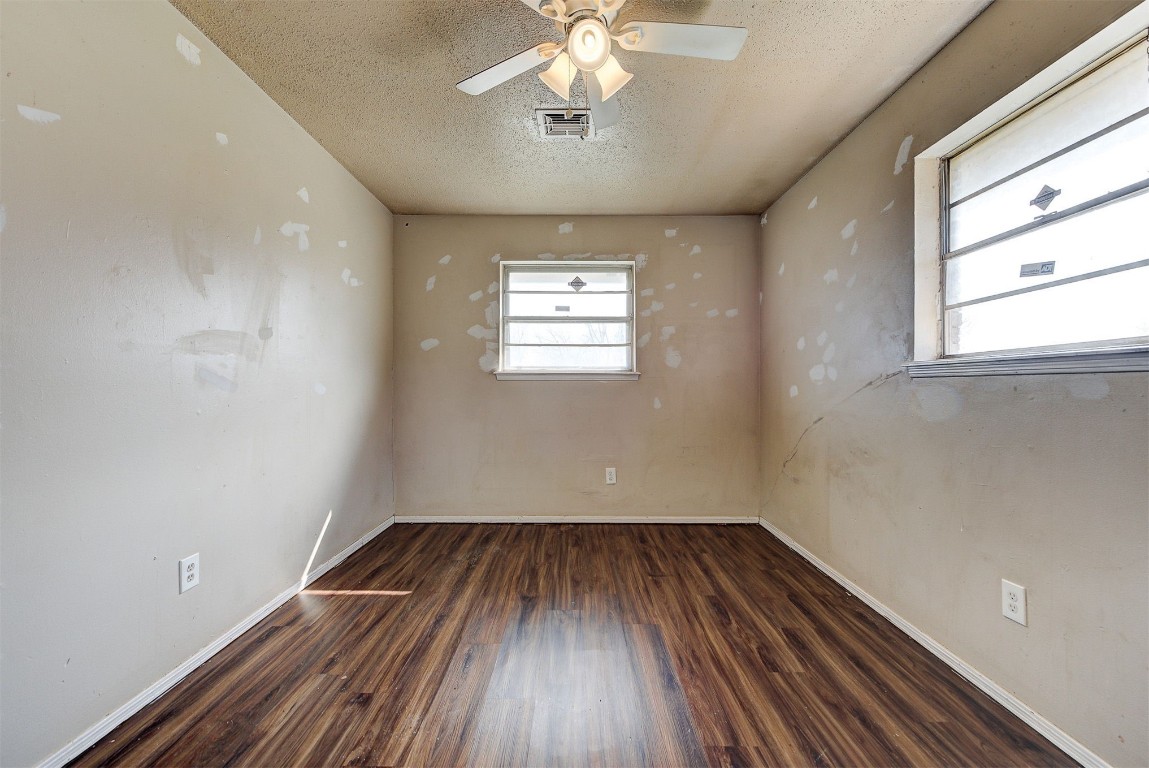 8709 N Hudson Avenue, Oklahoma City, OK 73114 unfurnished room with dark hardwood / wood-style floors, a textured ceiling, and ceiling fan