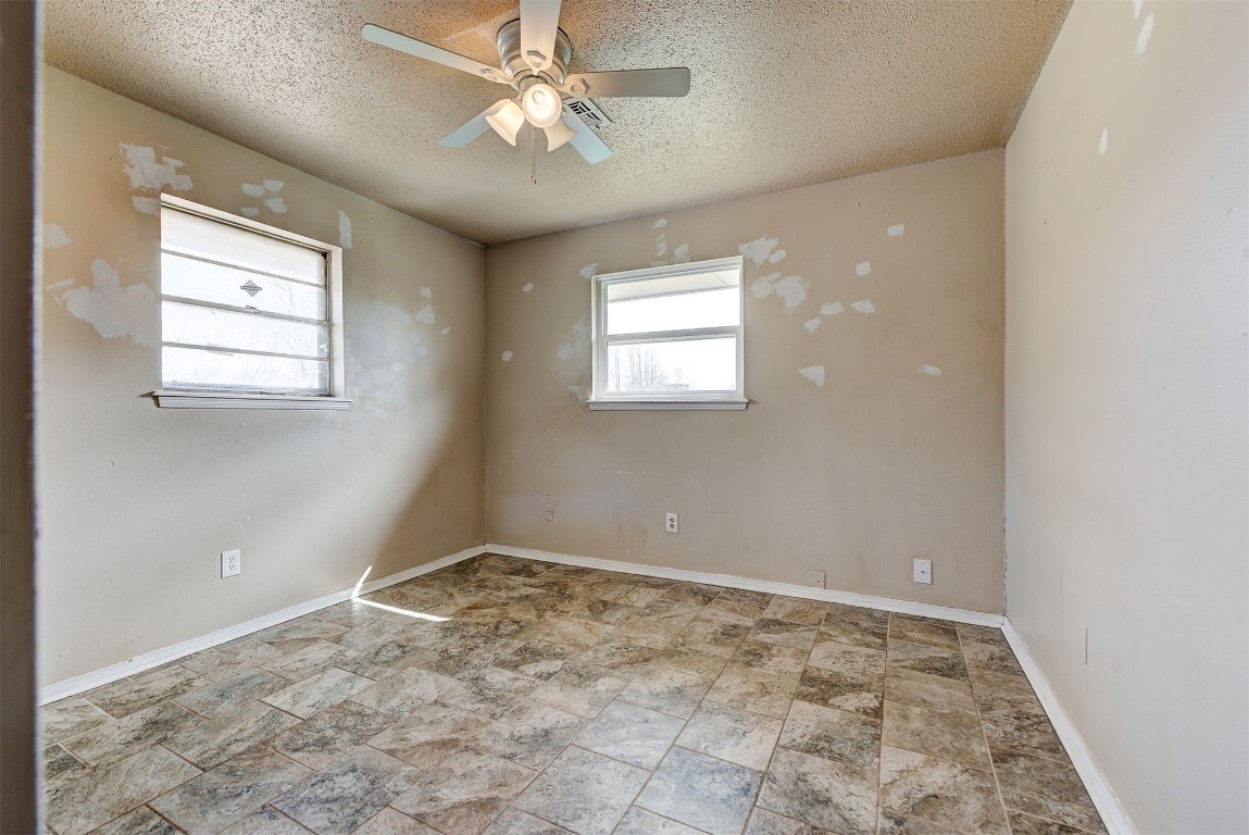 8709 N Hudson Avenue, Oklahoma City, OK 73114 tiled empty room featuring a textured ceiling and ceiling fan