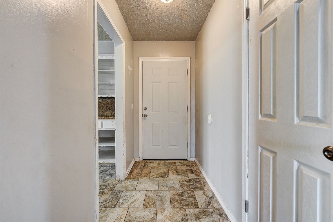 8709 N Hudson Avenue, Oklahoma City, OK 73114 entryway featuring light tile floors and a textured ceiling
