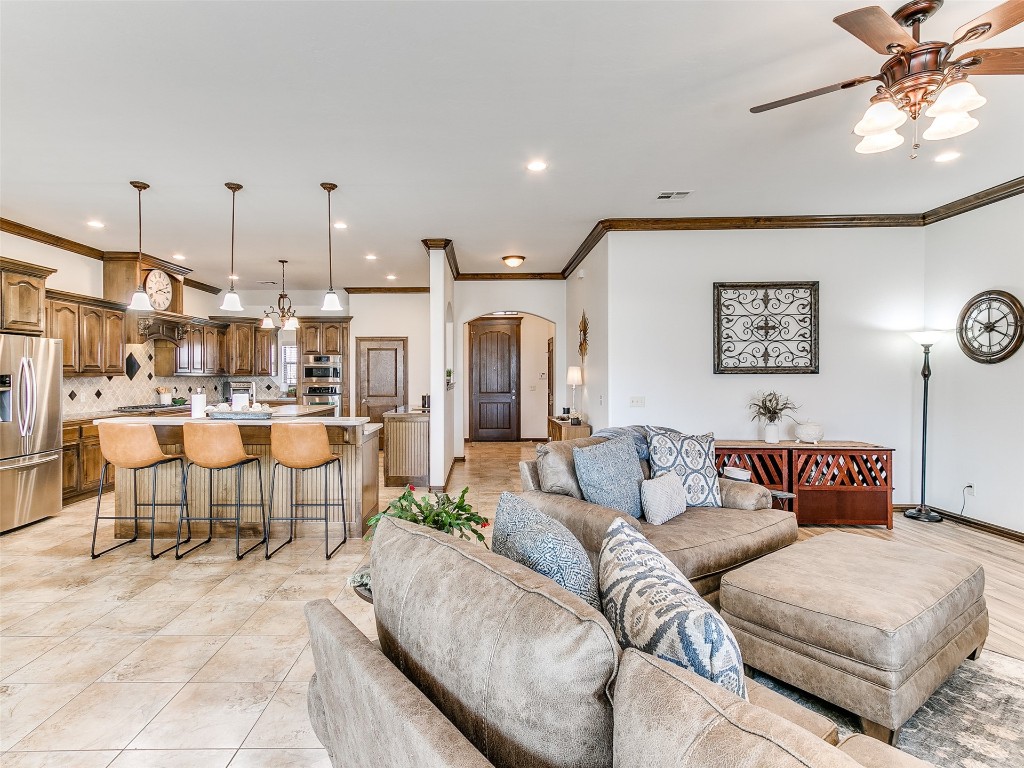 4610 Pikeys Trail, Tuttle, OK 73089 living room featuring ornamental molding, light tile flooring, and ceiling fan