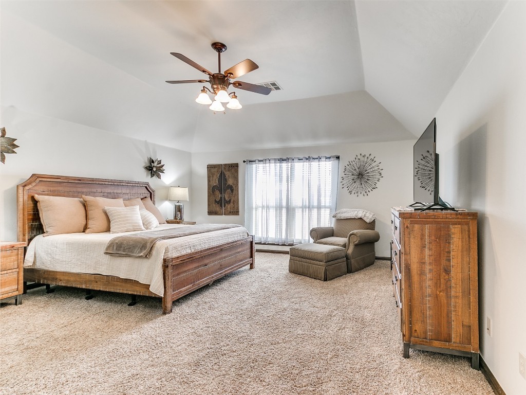 4610 Pikeys Trail, Tuttle, OK 73089 bedroom featuring light colored carpet, vaulted ceiling, and ceiling fan