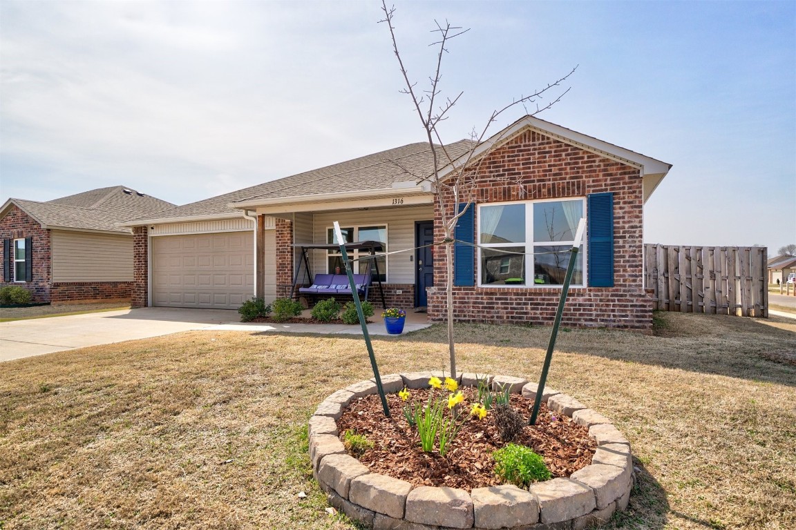 1316 Peridot Lane, Noble, OK 73068 single story home featuring a front lawn and a garage
