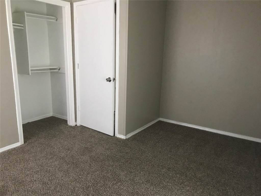 1501 Marydale Avenue, Midwest City, OK 73130 unfurnished bedroom with dark carpet and a closet