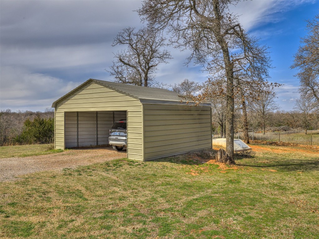 14051 Cemetery Road, Noble, OK 73068 garage featuring a lawn and a carport