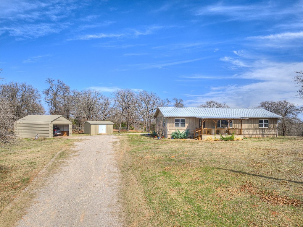 14051 Cemetery Road, Noble, OK 73068 ranch-style home featuring a porch, a front yard, and an outdoor structure