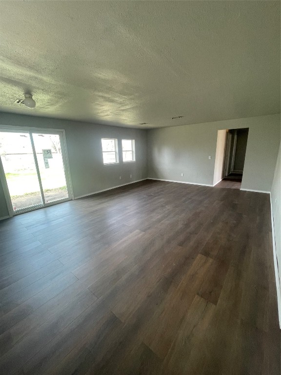 4017 SE 46th Street, Oklahoma City, OK 73135 empty room featuring dark hardwood / wood-style flooring and a textured ceiling