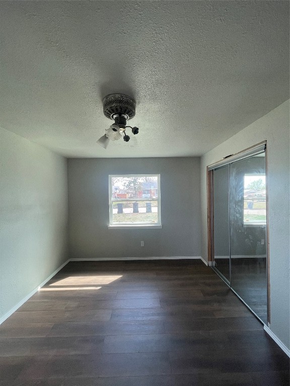 4017 SE 46th Street, Oklahoma City, OK 73135 unfurnished bedroom featuring dark hardwood / wood-style floors, multiple windows, and a closet