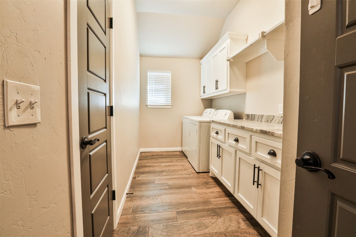12017 SW 50th Street, Mustang, OK 73064 clothes washing area featuring cabinets, independent washer and dryer, and light hardwood / wood-style floors