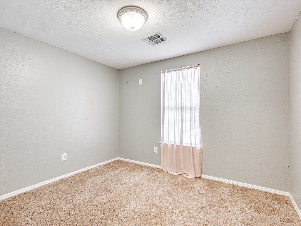 8416 NW 92nd Street, Oklahoma City, OK 73132 empty room with a wealth of natural light and light carpet