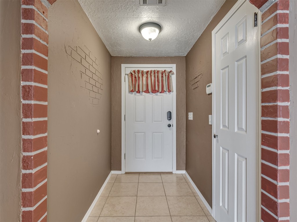8416 NW 92nd Street, Oklahoma City, OK 73132 doorway featuring a textured ceiling and light tile floors