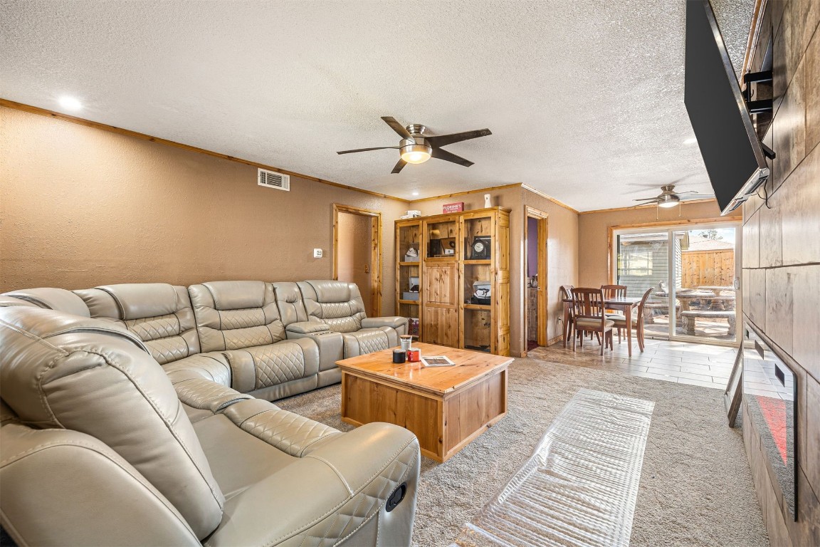 1804 NE 53rd Street, Oklahoma City, OK 73111 living room with light carpet, a textured ceiling, and ceiling fan