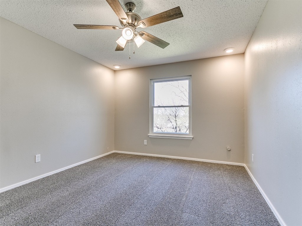 3421 Simmons Drive, Del City, OK 73115 empty room with a textured ceiling, carpet floors, and ceiling fan