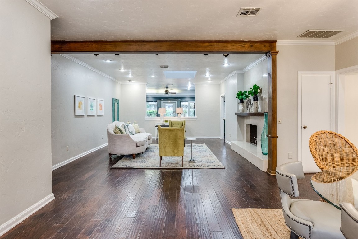 3904 Spyglass Road, Oklahoma City, OK 73120 living room with ornamental molding, beam ceiling, and dark wood-type flooring