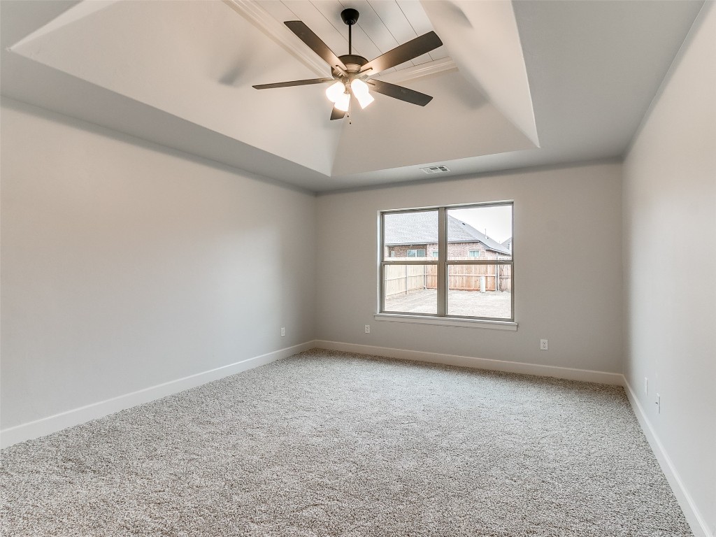 12105 SW 51st Street, Mustang, OK 73064 carpeted spare room with a tray ceiling and ceiling fan