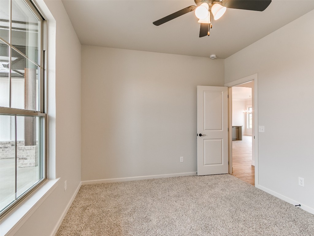 12105 SW 51st Street, Mustang, OK 73064 unfurnished room with light carpet and ceiling fan
