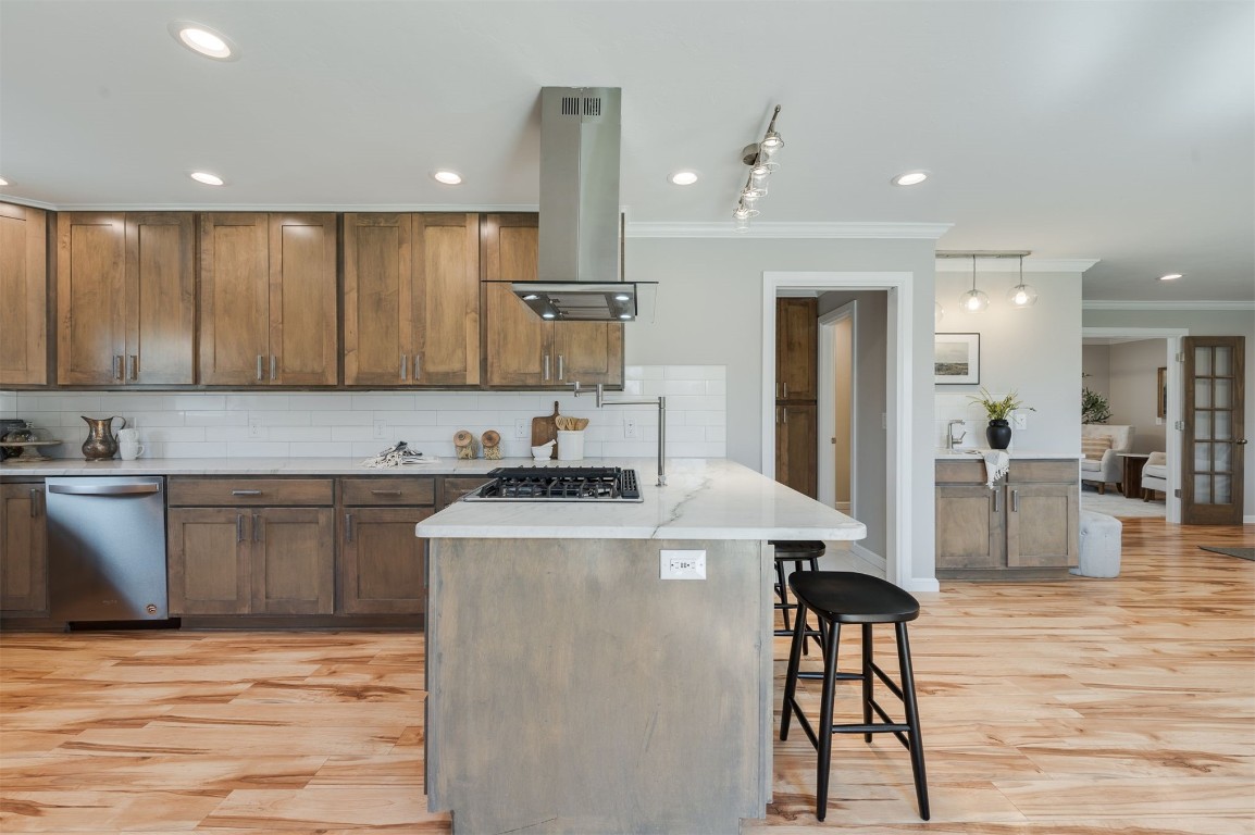 3108 Huntleigh Drive, Oklahoma City, OK 73120 kitchen featuring appliances with stainless steel finishes, backsplash, light hardwood / wood-style floors, and island range hood