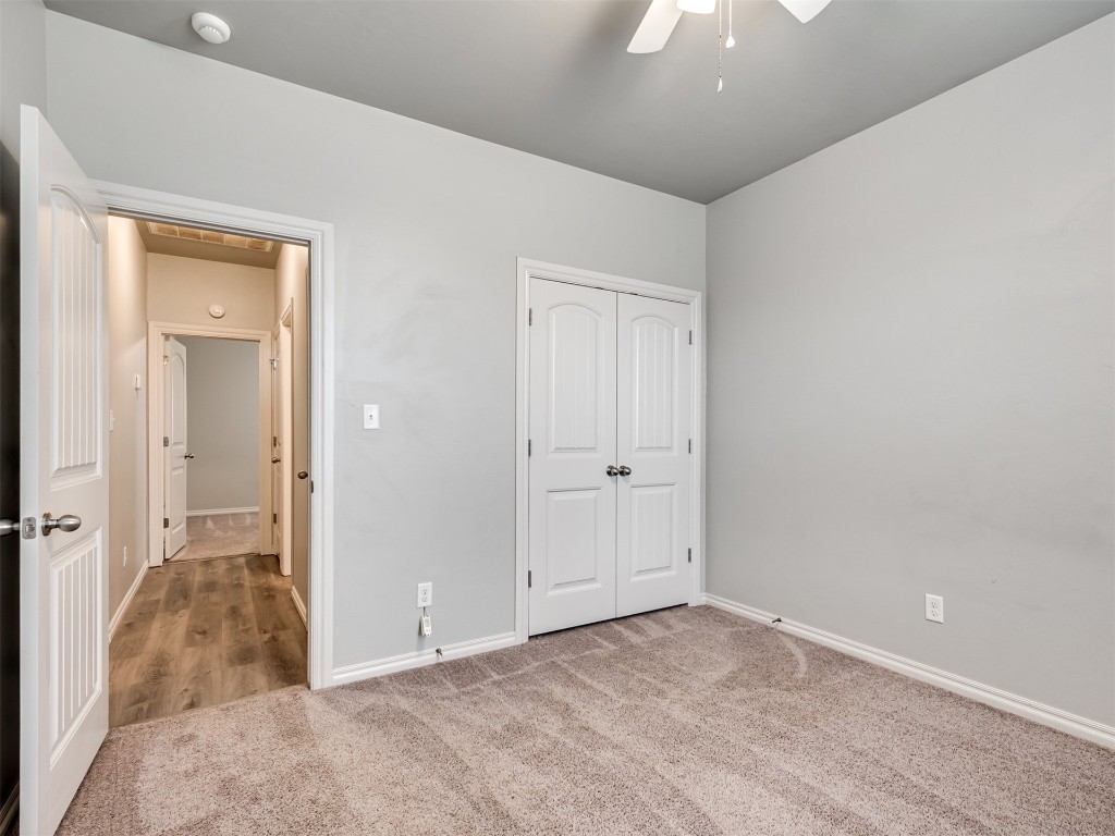 8208 NW 160th Terrace, Edmond, OK 73013 unfurnished bedroom featuring carpet, a closet, and ceiling fan