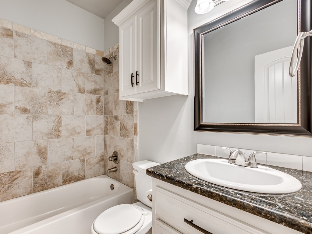 8208 NW 160th Terrace, Edmond, OK 73013 full bathroom featuring tiled shower / bath, large vanity, and toilet