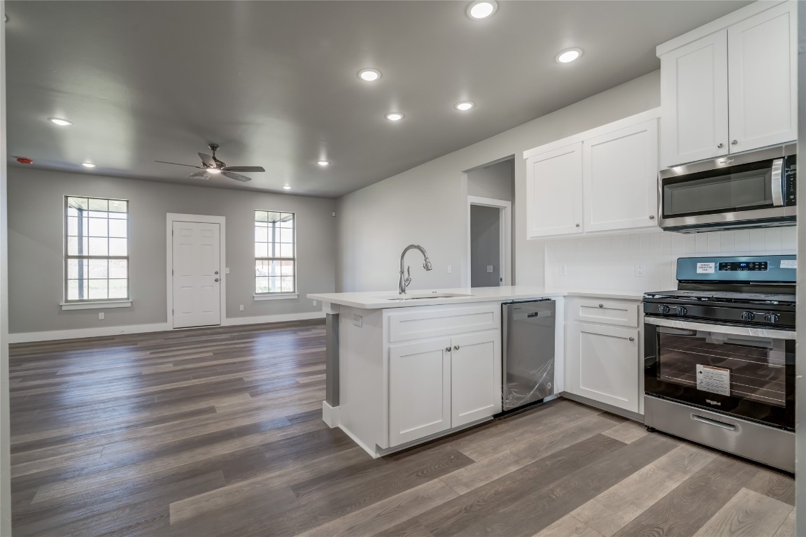 1525 NE 34th Street, Oklahoma City, OK 73111 kitchen featuring ceiling fan, dark hardwood / wood-style floors, kitchen peninsula, white cabinets, and stainless steel appliances