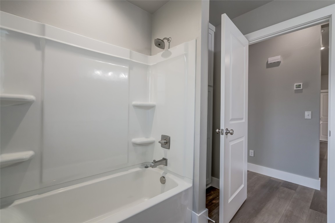 1525 NE 34th Street, Oklahoma City, OK 73111 bathroom with wood-type flooring and  shower combination