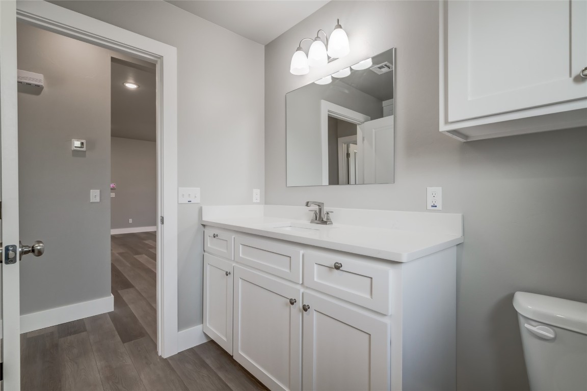 1525 NE 34th Street, Oklahoma City, OK 73111 bathroom with toilet, large vanity, and hardwood / wood-style floors