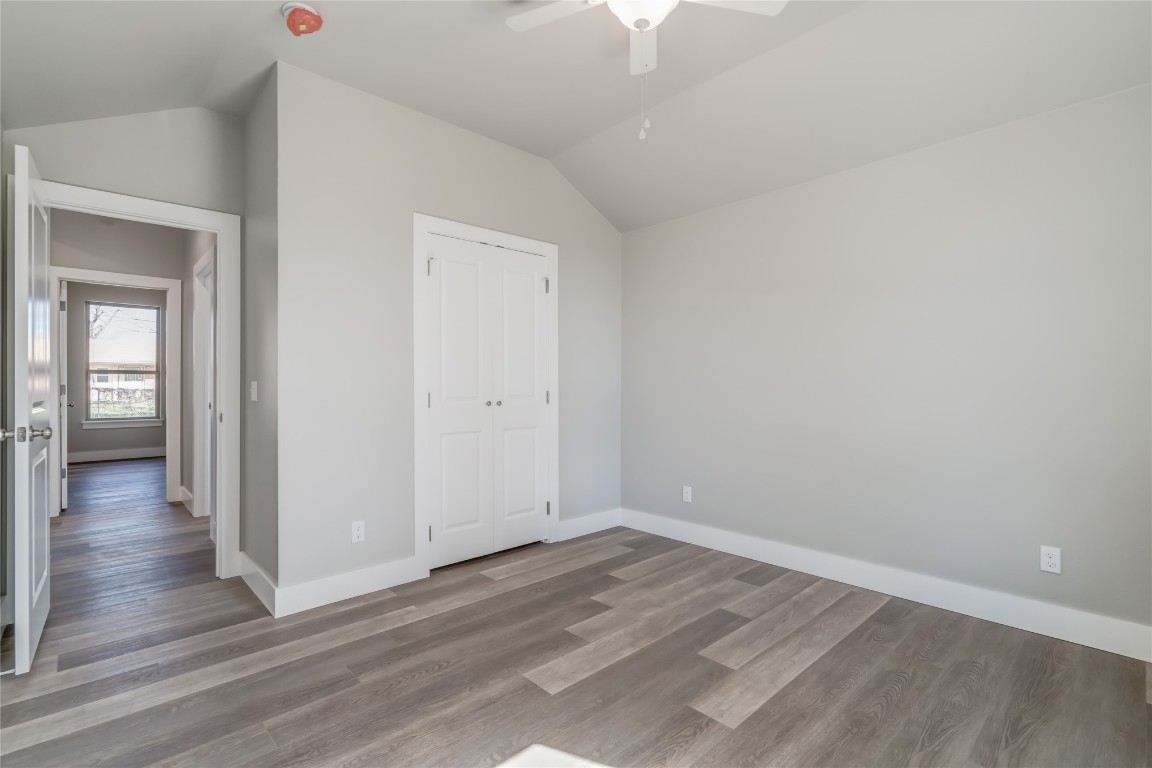 1525 NE 34th Street, Oklahoma City, OK 73111 unfurnished bedroom featuring lofted ceiling, dark hardwood / wood-style floors, a closet, and ceiling fan
