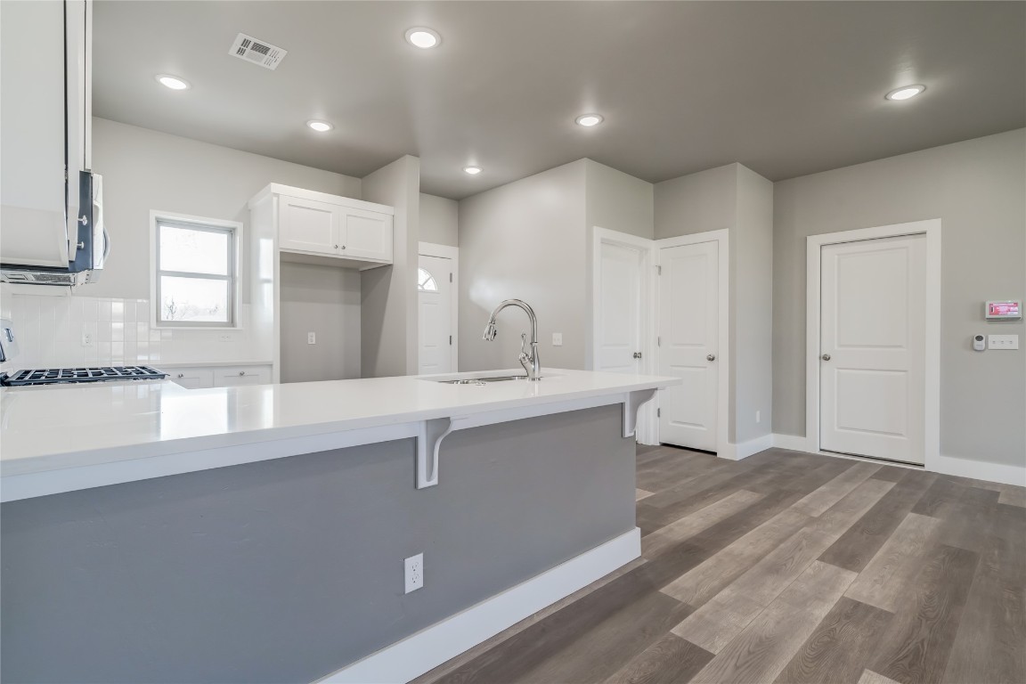1525 NE 34th Street, Oklahoma City, OK 73111 kitchen featuring tasteful backsplash, sink, range, dark wood-type flooring, and white cabinetry