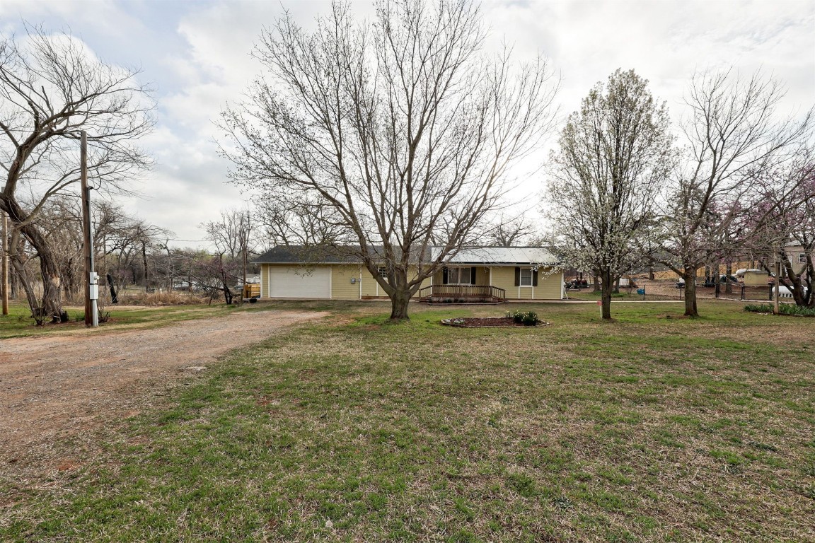 10774 S Pine Street, Guthrie, OK 73044 ranch-style home featuring a front lawn and a porch