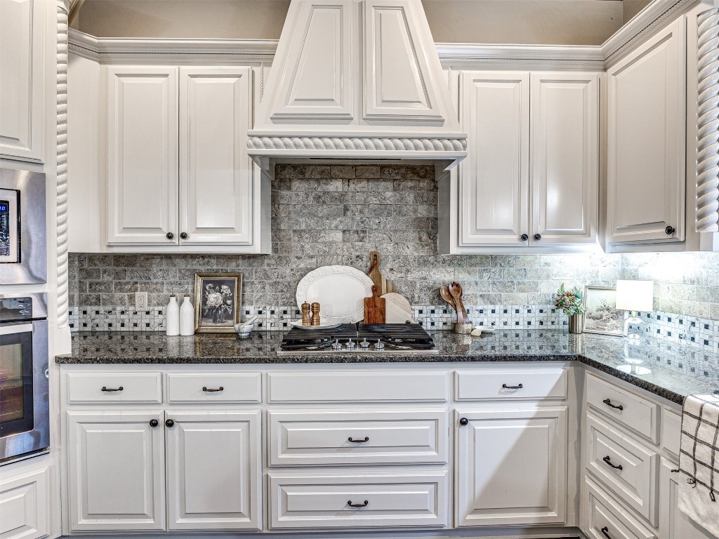 13512 Borgata Lane, Oklahoma City, OK 73170 kitchen featuring white cabinetry, tasteful backsplash, and appliances with stainless steel finishes