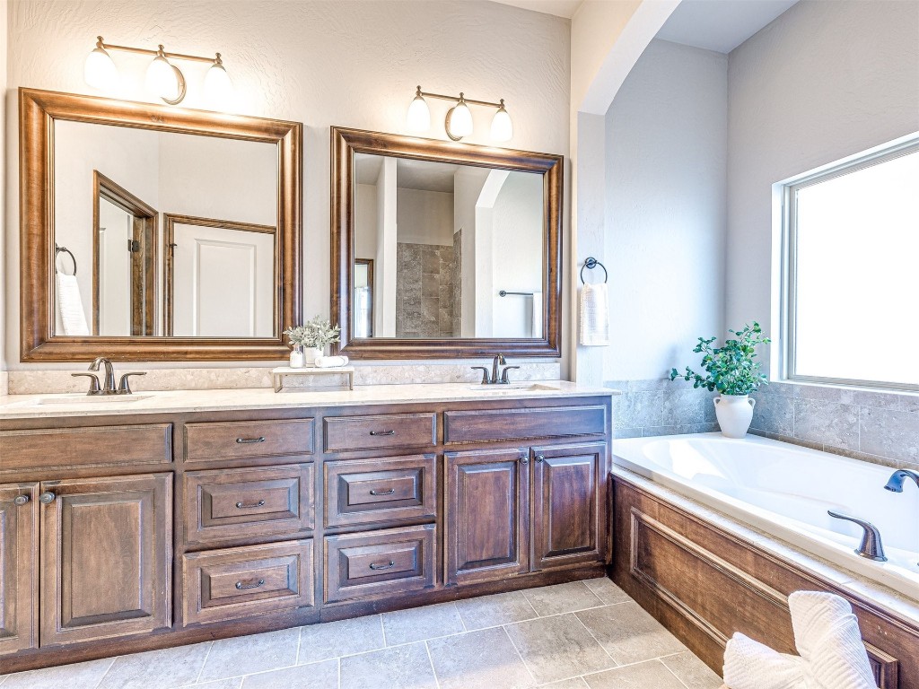 13512 Borgata Lane, Oklahoma City, OK 73170 bathroom with tile floors, a washtub, and dual bowl vanity