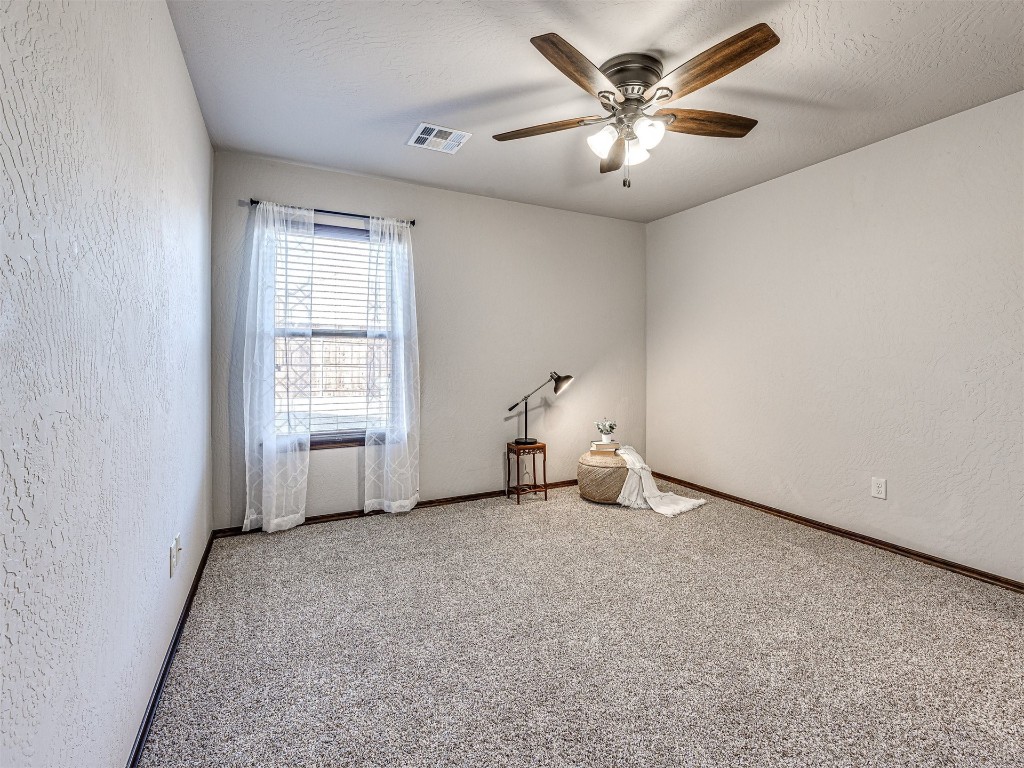 13512 Borgata Lane, Oklahoma City, OK 73170 spare room featuring light carpet, a textured ceiling, and ceiling fan