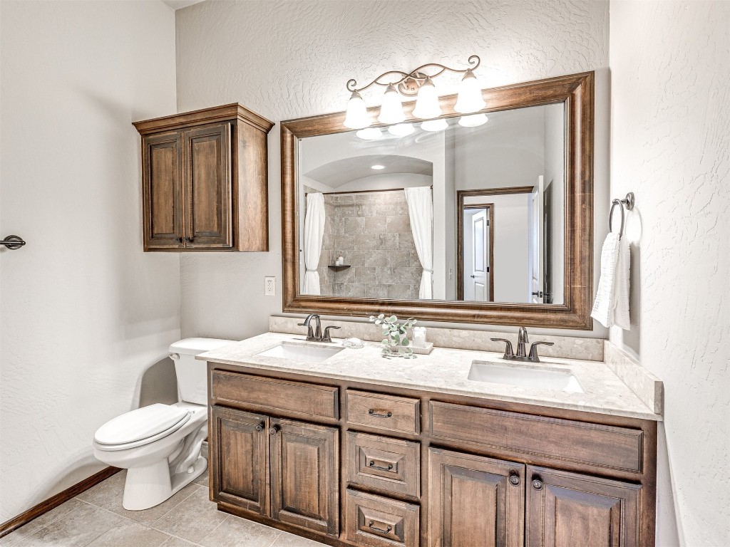 13512 Borgata Lane, Oklahoma City, OK 73170 bathroom with tile floors, dual bowl vanity, and toilet