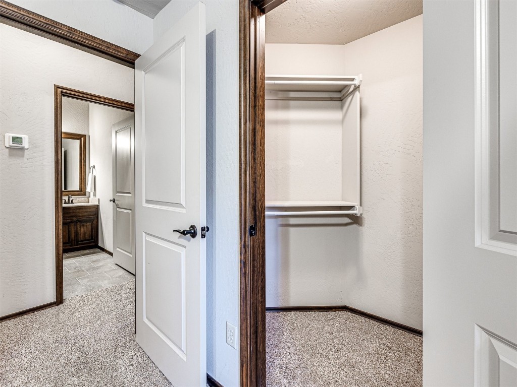 13512 Borgata Lane, Oklahoma City, OK 73170 walk in closet featuring sink and light colored carpet